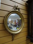 A circular ornate gilt wall mirror