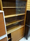 A vintage lightwood bookcase sliding glass door top above a sliding cupboard base