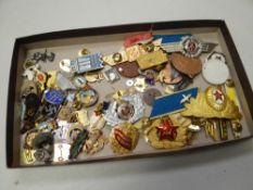 A collection of mainly Russian military insignia together with a bag of various enamelled pin