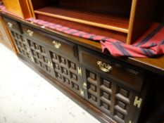 A dark oak long sideboard with four drawers above a four cupboard base & brass fittings from the