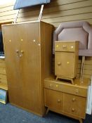 A vintage light oak bedroom suite comprising two-door wardrobe, bedside cabinet, small chest, pair