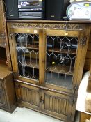 A vintage oak leaded glazed cupboard bookcase