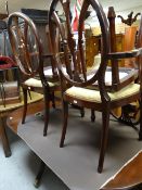 A reproduction mahogany twin-pedestal dining table together with six (4+2) matching shield back