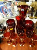 A tray of red glass items including vases, drinking glasses etc