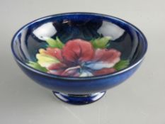 A MOORCROFT 'HIBISCUS' 14 cms PEDESTAL BOWL decorated on a cobalt blue ground, 6.5 cms high,