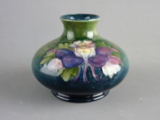 A MOORCROFT 'COLUMBINE' 8.5 cms HIGH SQUAT VASE decorated on a tonal green/blue ground, impressed