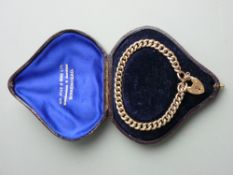 A NINE CARAT GOLD CURB LINK BRACELET with padlock clasp and safety chain, 10.2 grms gross in a