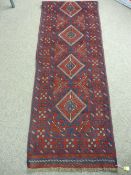 A MESHWANI RUNNER with central repeating diamond pattern and block pattern border on a red and