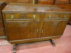A VINTAGE OAK RAILBACK SIDEBOARD having two drawers and two cupboard doors with blind fret