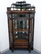 A HIGH VICTORIAN ROSEWOOD CORNER DISPLAY CABINET having a three tier mirrored structure with