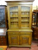 AN OAK ARTS & CRAFTS BOOKCASE TOP SIDEBOARD having an inverted step crown over twin leaded glazed