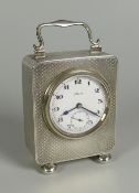 A SILVER BEDROOM CLOCK with fine machine-turned encasement, circular white dial bearing Arabic