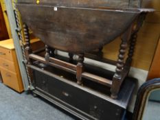 A circular oak gate leg dining table together with oak low blanket box / coffer