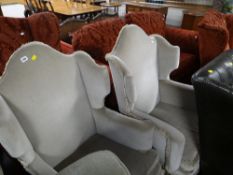 A pair of vintage pale green velour arch topped wingback armchairs