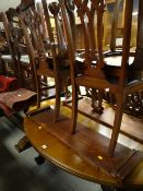An oval extending mahogany dining table (two leaves) & four Chippendale-style carved back chairs