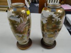 A pair of Japanese Satsuma ware decorated vases on stands