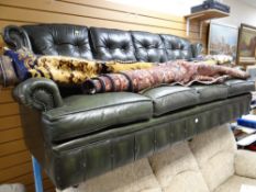 A four-seater buttoned green leather settee