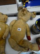 A vintage store stuffed teddy bear with the head moving left to right & with red paw pads