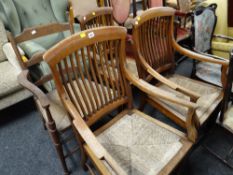 A pair of light oak rush seated spindle backed armchairs together with two other similar rush seated