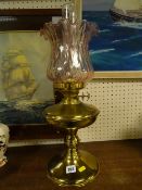 Brass oil lamp with pink glass shade