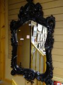 Large elaborately decorated matt black framed wall mirror