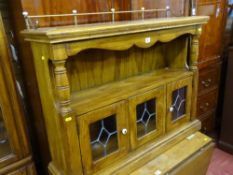 Modern wooden hall unit having two glazed and leaded doors with upper shelf and brass gallery top