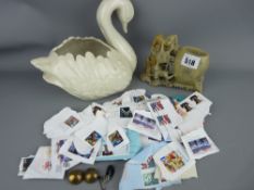 Carved soapstone vase and a white pottery swan vase containing a quantity of envelope removed stamps