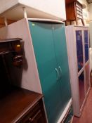 Compact wardrobe of two doors over two drawers and a white ottoman