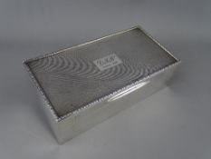 A SILVER CIGARETTE BOX, London 1929, 18 cms long