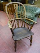 AN ANTIQUE WINDSOR FARMHOUSE ARMCHAIR with crinoline stretcher, 97 cms high, 56 cms wide, 38 cms
