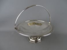 A SILVER SWING HANDLED PEDESTAL BASKET, 27.5 cms diameter by Walker & Hall, Sheffield 1906, 23