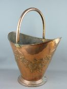 A COPPER HELMET SHAPED COAL SCUTTLE with raised floral decoration, 54 cms high overall