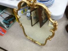 Elaborately shaped gilt framed wall mirror