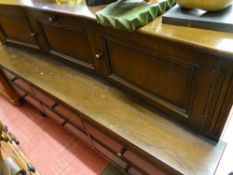 Polished wood sideboard of three upper cupboards and a bank of six lower drawers