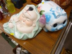 Oriental pottery figurine of a baby asleep amongst lotus leaves and a large pottery piggy bank