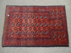 Eastern Baluchi rug, red ground with repeating block central pattern and continuous border