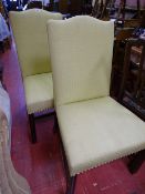 Pair of yellow upholstered and studded high back chairs