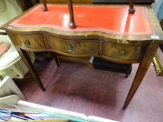 Reproduction mahogany serpentine front desk with gilt tooled red leather top