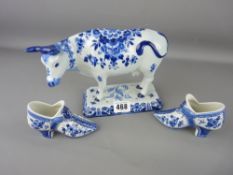 Oblong based blue and white Delft cow and pair of similar ornamental shoes