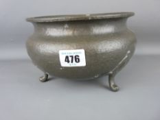 Circular beaten pewter bowl on three supports