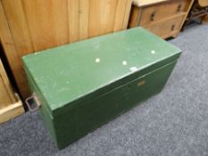 A painted green small wooden trunk with carry handles