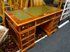 A reproduction yew wood kneehole desk with three drawers & green leather tooled top. Height - 75cms,