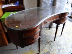 A glass top kidney shaped mahogany crossbanded dressing table