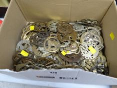A box of various loose horse brasses