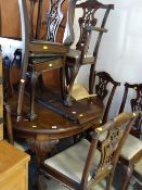 An early twentieth century mahogany circular extending dining table with ball & claw feet together