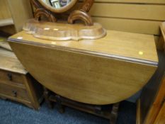 A vintage oak drop leaf gate legged dining table