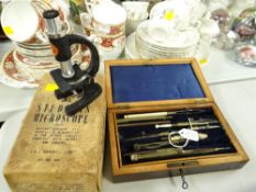 Vintage cased wood box of drawing tools together with a Merit student's microscope