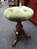 A buttoned cushion circular telescopic piano stool on tripod feet