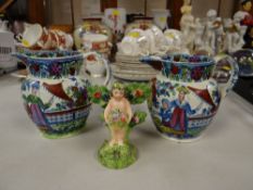 Two decorated Staffordshire jugs & Staffordshire putto