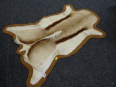 An African elan hide small rug together with a patterned woollen carpet, 260 x 222 cms